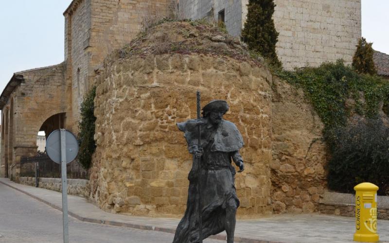 Peregrino, al fondo Iglesia de Santa María del Camino y muralla